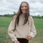 Frau trägt den Eringenser von Rauma in Natur und Hellbeige – kurzer Pullover mit markanten Raglanlinien aus Fivel und Alpakka Lin Tweed