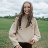 Frau trägt den Eringenser von Rauma in Natur und Hellbeige – kurzer Pullover mit markanten Raglanlinien aus Fivel und Alpakka Lin Tweed