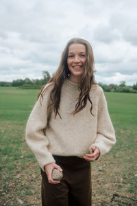 Frau trägt den Eringenser von Rauma in Natur und Hellbeige – kurzer Pullover mit markanten Raglanlinien aus Fivel und Alpakka Lin Tweed