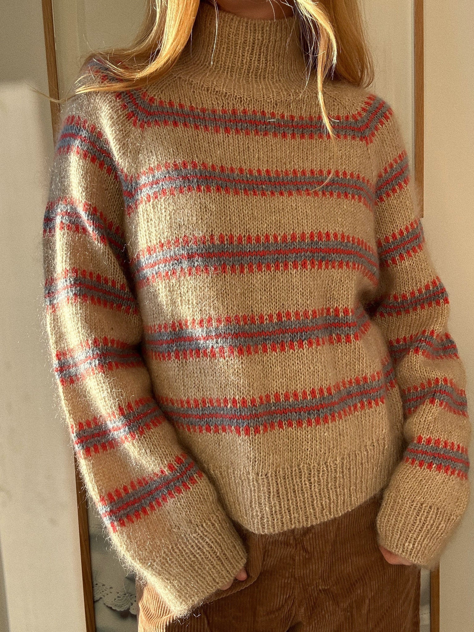 Norma Sweater mit Stehkragen und Farbmuster in Rot und Hellblau auf sandfarbenem Grund