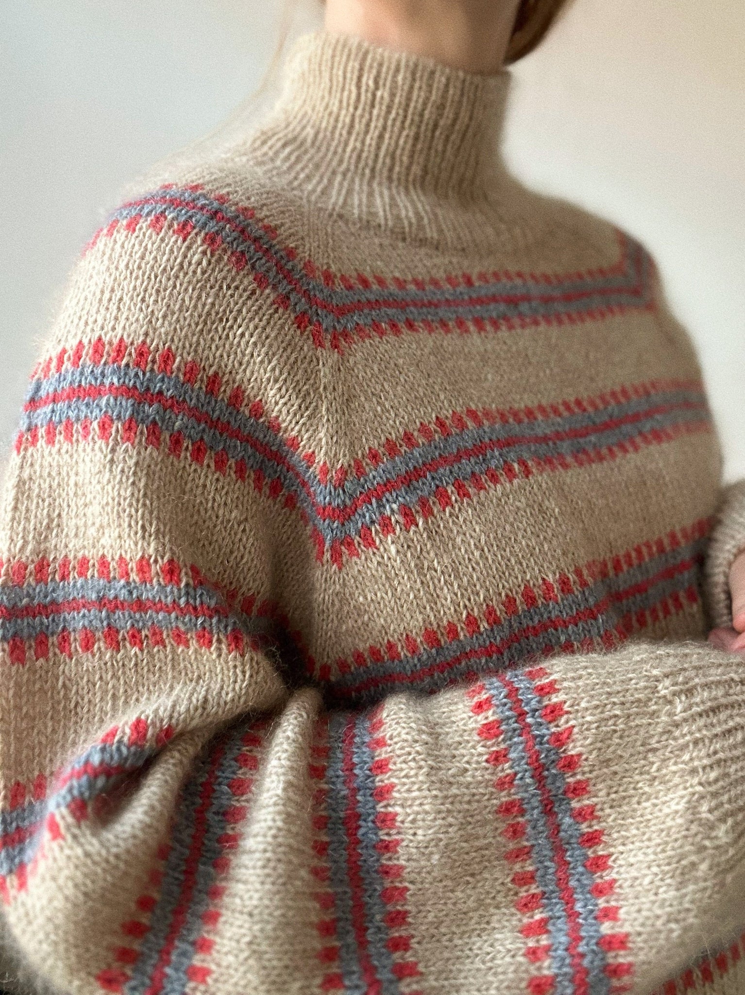 Norma Sweater in Sand mit roten und hellblauen Details, gestrickt aus Isager Tweed, Silk Mohair und Tvinni