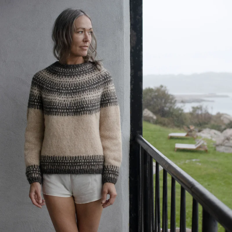 Frau trägt den Badger and Bloom Unisex Pullover von Anne Ventzel mit mehrfarbiger Rundpasse, gestrickt aus Isager Soft