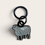 Firefly Notes Maschenmarkierer Meadow Sheep aus Metall und Emaille, cremeweißes Schaf mit schwarzem Ring, Nahaufnahme auf hellem Hintergrund