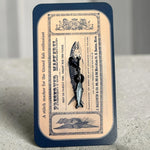 Firefly Notes Maschenmarkierer Preserved Mackerel aus Metall und Emaille, silberne Makrele mit schwarzem Hakenverschluss auf Karte mit Vintage-Fischdosenetikett „Preserved Mackerel“
