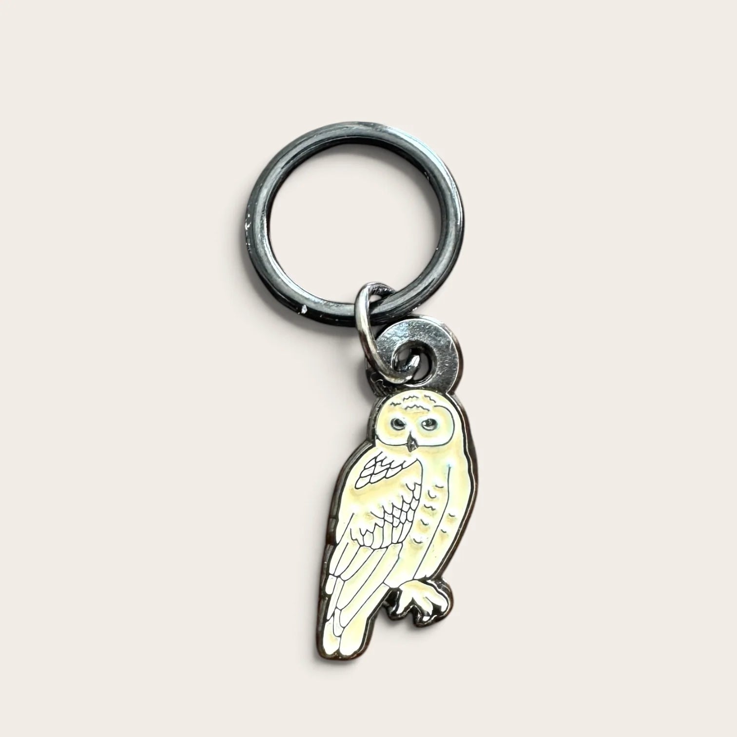 Firefly Notes Maschenmarkierer Snowy Owl aus Metall und Emaille, cremeweiße Schneeeule mit schwarzem Ring, Nahaufnahme auf hellem Hintergrund