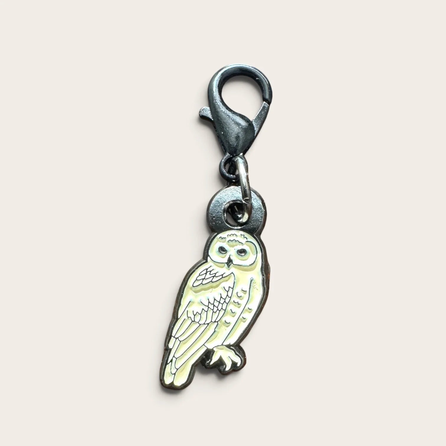 Firefly Notes Maschenmarkierer Snowy Owl aus Metall und Emaille, cremeweiße Schneeeule mit schwarzem Hakenverschluss, Nahaufnahme auf hellem Hintergrund