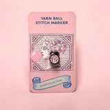 Firefly Notes Maschenmarkierer Yarn Ball in Bubblegum Pink aus Metall und Emaille, rosa Wollknäuel mit schwarzem Ring auf rosa Karte mit Vintage-Briefmarke und Frauenprofil mit Kaugummiblase