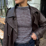 Frau trägt die blau-bordeaux gestreifte Frankie Blouse aus Silk Mohair unter einer offenen Lederjacke